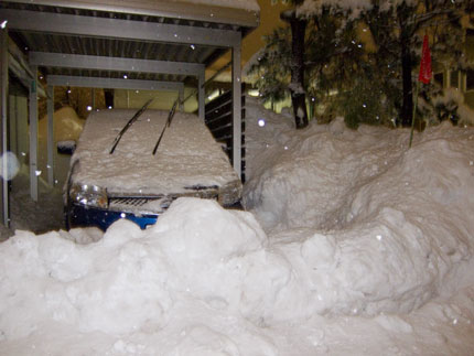 除雪車が大量の雪を車庫の前に置いて行きます