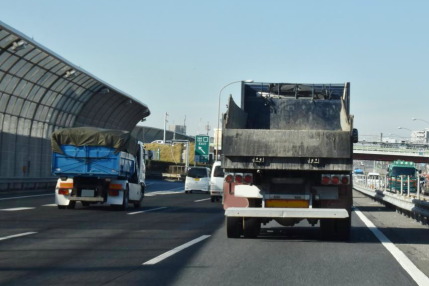 トラックの荷台から土砂や水をこぼしながら走る