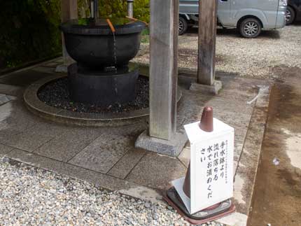 手水鉢より流れ落ちる水で直接手を清める